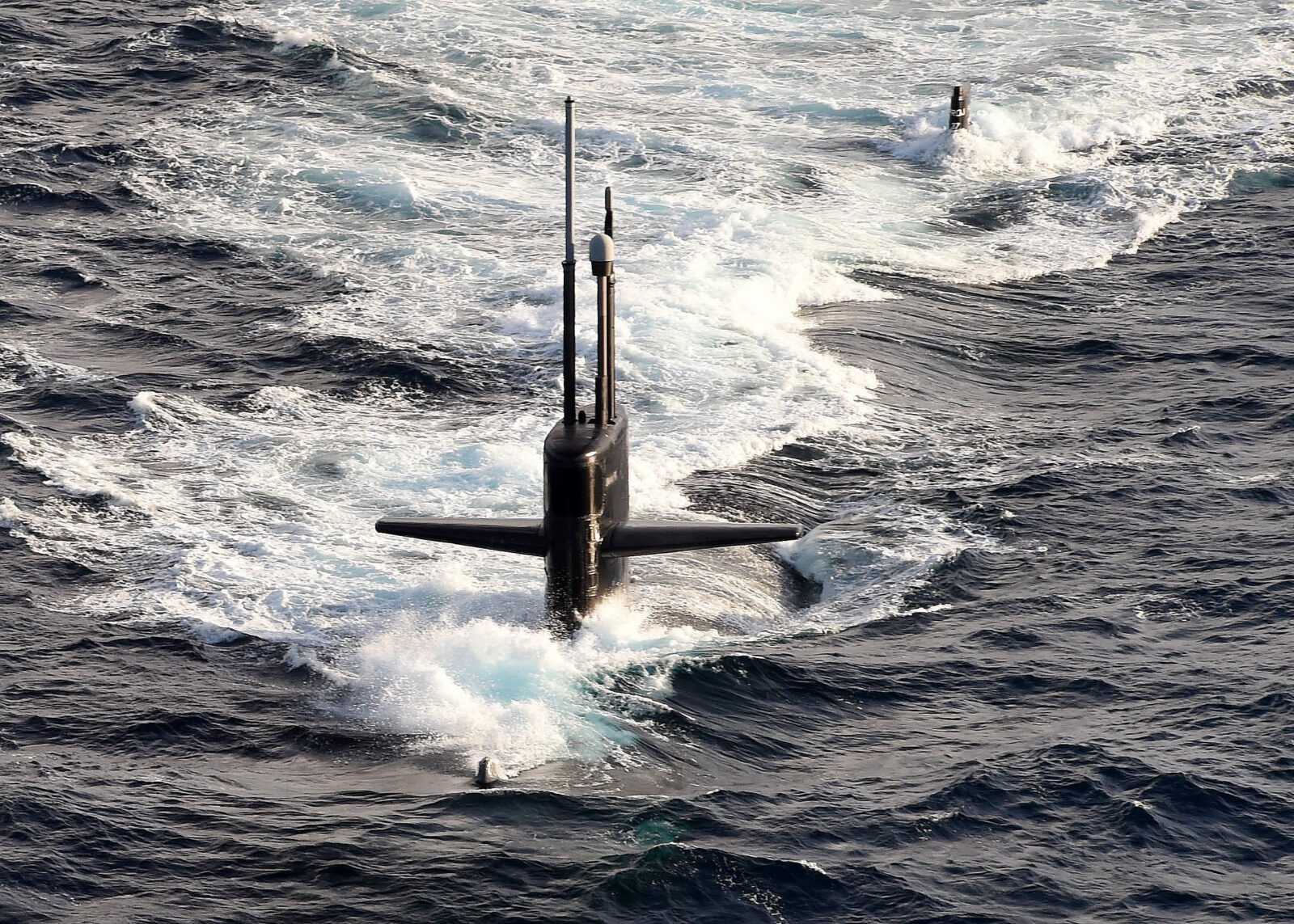 Submarine traveling on the ocean surface amid rough waves