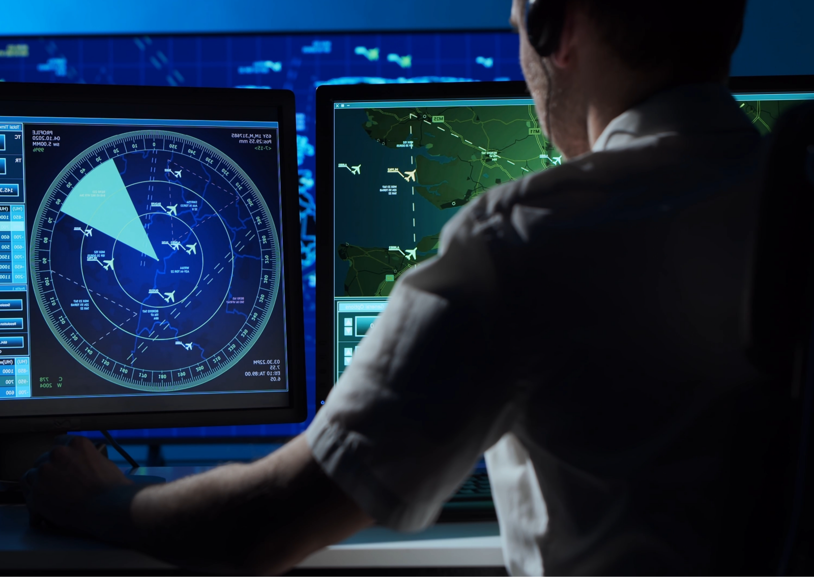 Workstation with radar and map displays showing tracked aircraft on multiple monitors