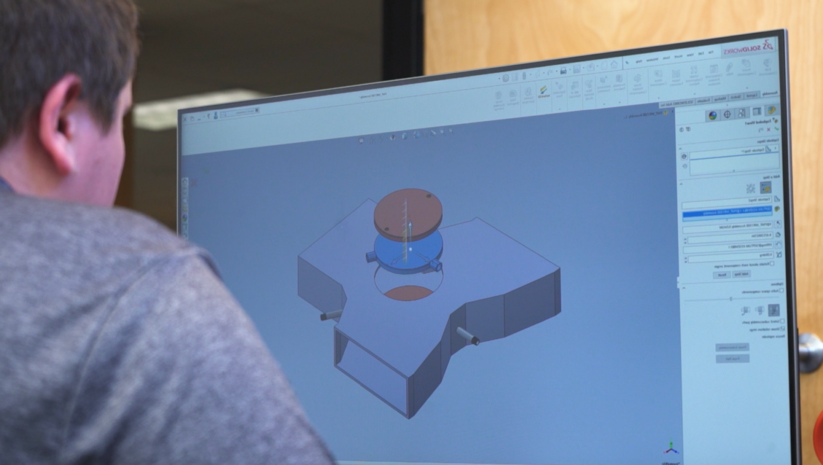 Computer screen displaying a 3D CAD model of a mechanical part