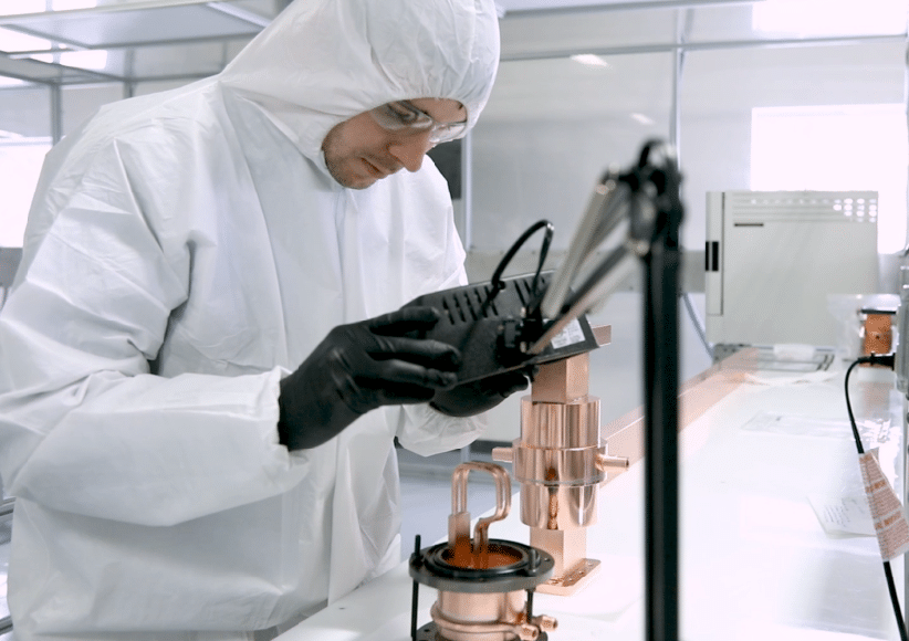 Technician operating a precision instrument inside a controlled laboratory environment
